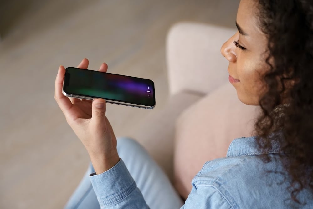 a woman recording a podcast on a smart phone