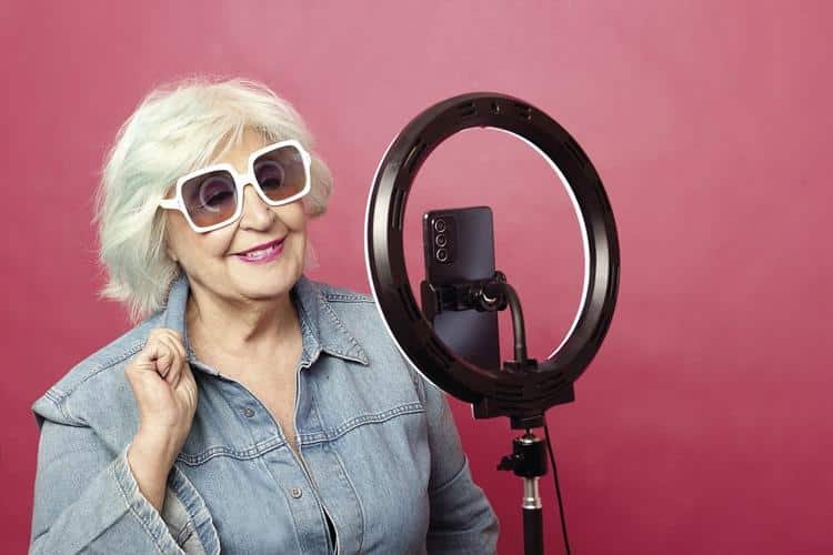 woman over 50 in front of a ring light making a reel