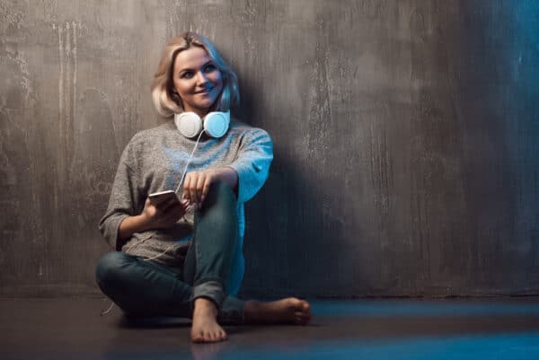 woman podcasting on a budget with a smart phone and headphones