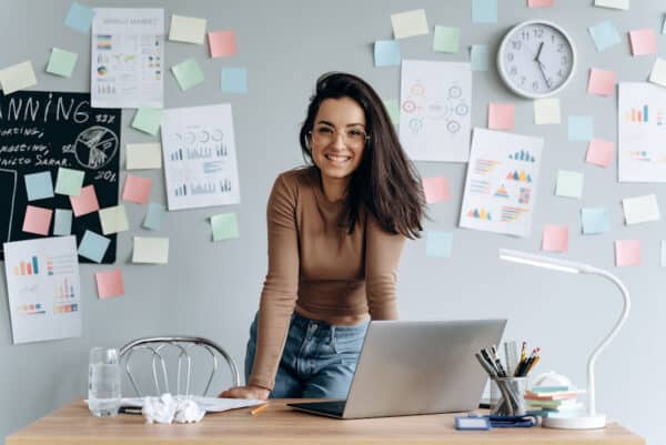 smiling woman standing at a desk